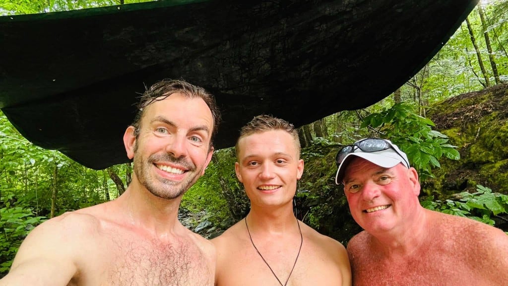 Under the shade tarp Three friends smiling under a shade tarp on the green riverbank at Rock River, Newfane Vermont — August swim day in southern Vermont