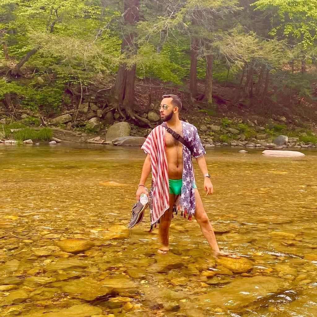 Visitor wading in clear Rock River water — arrival and shoreline context, Windham County, Vermont.
